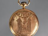 a gold pocket watch with a picture of a bird on it