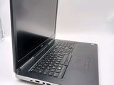 a laptop computer sitting on a table with a glass of water in front of it