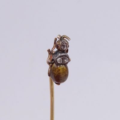 un petit objet marron fixé à un bâton posé sur une surface blanche