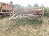 un tracteur garé dans l'herbe, avec une remorque derrière lui