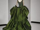 une photo d'un mannequin portant une robe verte dans une pièce