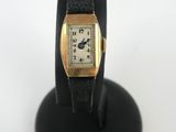 an image of a gold plated wrist watch on a black stand