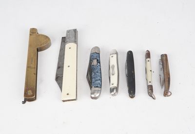 plusieurs types de couteaux sont alignés sur une surface blanche