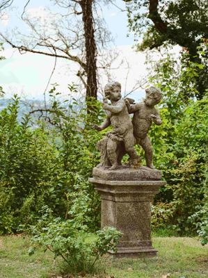 une statue représentant un garçon et un chien, posée sur un socle