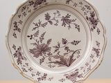 une assiette marron et blanche posée sur une table en bois