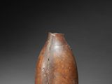 an old brown vase sitting on top of a gray surface