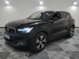 un SUV Volvo noir garé dans une grande pièce au sol carrelé