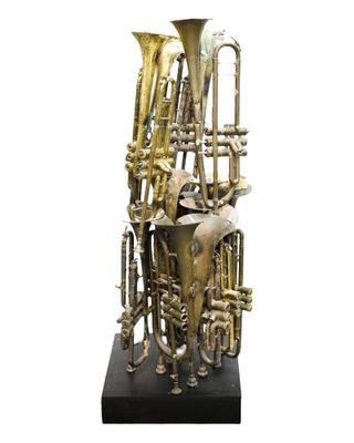 a brass sculpture of a musical instrument on a black base