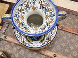 a blue and white cup sitting on top of a suitcase