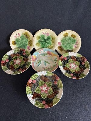 Plusieurs assiettes et bols sont disposés en cercle sur une surface noire.