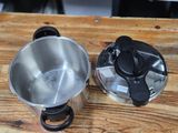 two pots that are sitting on a wooden table