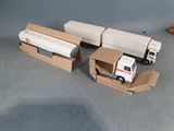 two toy trucks that are sitting in a cardboard box