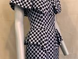 Le mannequin porte une robe noire et blanche à pois.