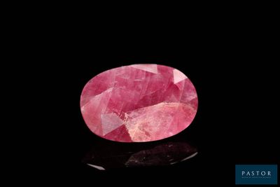 a pink tourmaline gems on a black surface