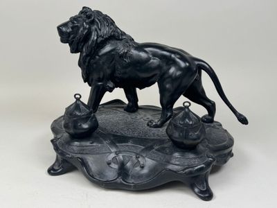 statue of a lion on a rock with a bell in its mouth