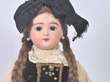 a doll that is wearing a dress and a hat