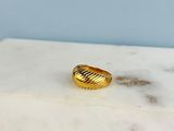 La bague en or repose sur une table en marbre.