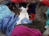 a large pile of clothes in a basket on the floor