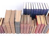 several old books stacked on top of each other on a white surface
