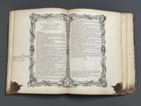 an old open book with writing on it sitting on top of a table