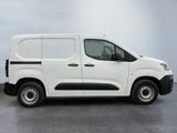 the white van is parked in a room with a gray floor