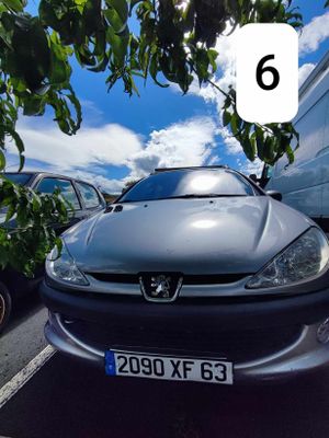 une voiture argentée garée dans un parking à côté d'autres voitures