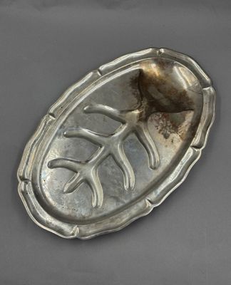 un vieux plat en argent orné d'un motif de feuilles