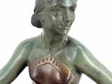 a bronze statue of a woman sitting on a chair