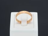 a close up of a gold ring on a white box