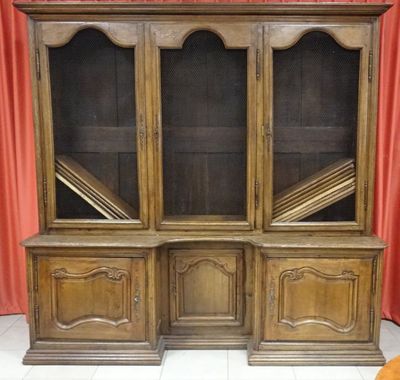 an old wooden bookcase with glass doors and shelves on a tiled floor