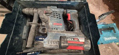une perceuse sans fil dans une boîte à outils avec un marteau