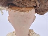 an old doll with a brown hair and a white dress