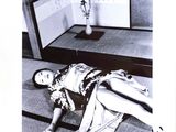 a black and white photo of a woman laying on the floor