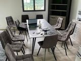 plusieurs chaises disposées autour d'une table sur laquelle est posé un ordinateur portable