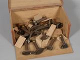 une boîte en bois remplie d'outils divers et une boîte sur laquelle sont apposées des étiquettes