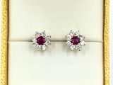 une paire de boucles d'oreilles en rubis et diamants dans un écrin