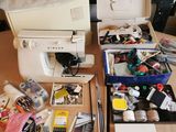une table sur laquelle se trouvent une machine à coudre et de nombreux autres objets