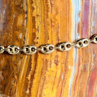 a close up of a gold chain on a rock