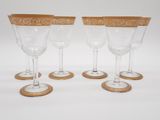 quatre verres à vin à bord doré sur fond blanc