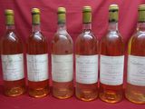 six bouteilles de vin sont alignées sur un fond rouge