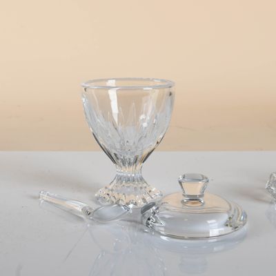 a glass bowl and a glass spoon sitting on a table