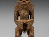 une image représentant une statue d'un homme assis à genoux