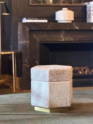 a small stool sitting in front of a fireplace in a living room