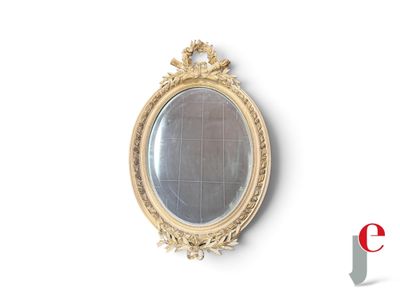 a gold oval mirror on the wall with a white background