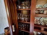 une armoire en bois sur laquelle sont posés de nombreux verres et assiettes