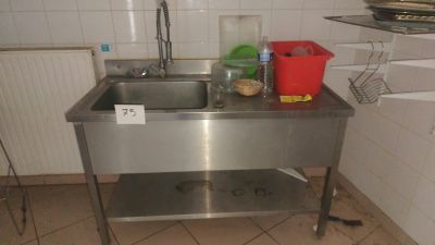 a stainless steel sink in a kitchen with a red bucket