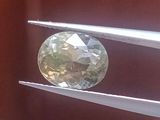 un diamant vert et blanc maintenu par une pince