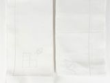 two white napkins with embroidered monograms on them on a white surface