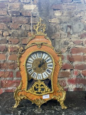 une horloge posée sur une table devant un mur de briques