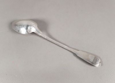 une cuillère en argent avec un manche de cuillère sur une table